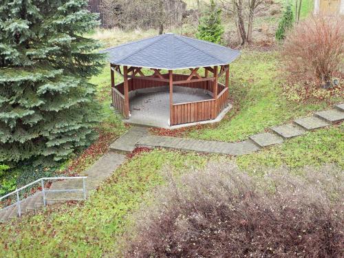 a gazebo with a black roof in a garden at Peaceful Villa in Borstendorf in Leubsdorf