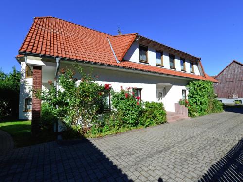 ヴィリンゲンにあるHolidays in the Sauerland region Apartment in a unique location with use of the gardenのオレンジの屋根と私道のある白い家