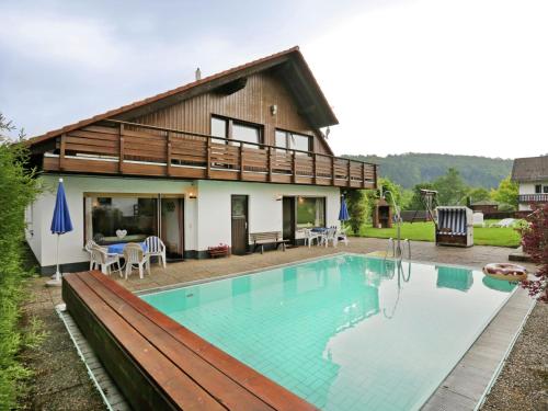 a house with a swimming pool in front of it at Apartment in Armsfeld with heated outdoor pool in Bergfreiheit