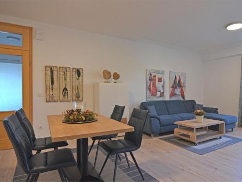 MadfeldにあるTasteful apartment in Brilon with terraceのリビングルーム(テーブル、青いソファ付)