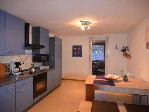 a kitchen with blue cabinets and a counter top at Bright apartment in the Sauerland with conservatory large terrace and awning in Assinghausen