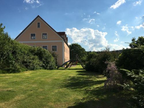 a house on a hill with a grass yard at Spacious Apartment in Schönsee with Sauna in Dietersdorf