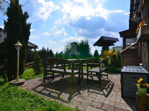 een picknicktafel en twee banken in een tuin bij Cosy apartment in Frauenwald near forest in Frauenwald