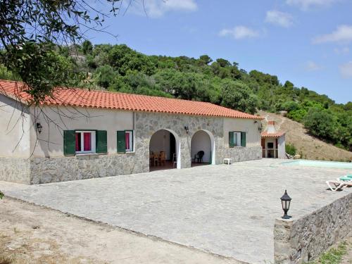 a stone house with a pool in front of it at Belvilla by OYO Canyar Enzell in Es Mercadal