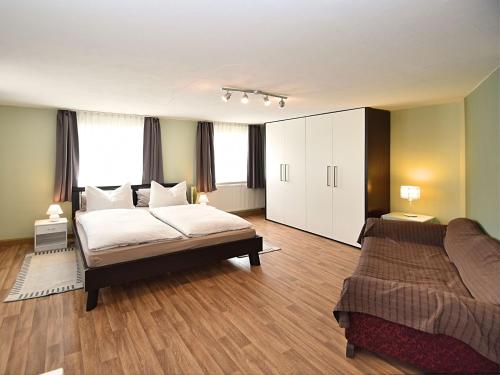 1 dormitorio con 1 cama y 1 sofá en Holiday home with garden near the forest, en Arnschwang