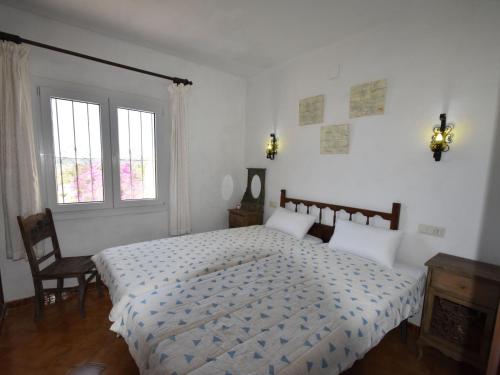 モライラにあるBelvilla by OYO Casa Kolaの白いベッドルーム(ベッド1台、窓付)