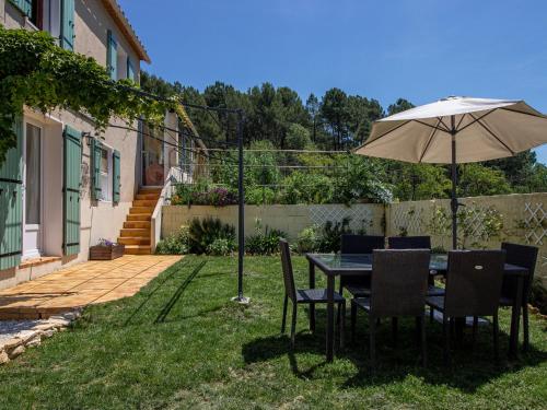 a table and chairs with an umbrella in a yard at Apartment in Gargas near Route des Ocres in Gargas