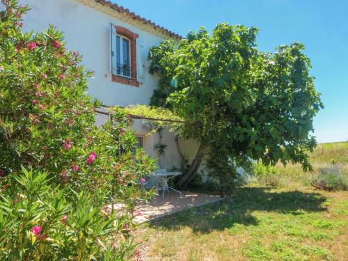 uma vista exterior de uma casa com árvores e flores em Spacious 6 person villa with pool em Autignac