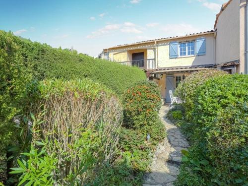 a house with a hedge in front of a building at Modern holiday home with swimming pool in Peymeinade