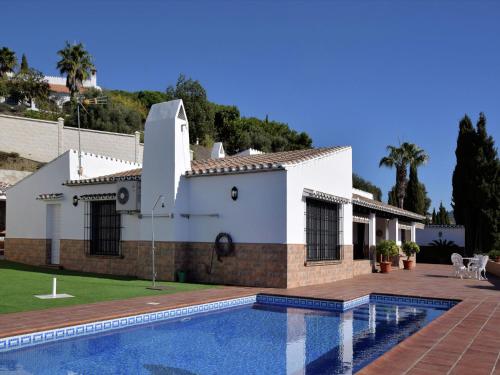 uma casa com uma piscina em frente em Belvilla by OYO Casa Loli em Algarrobo