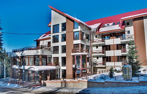 un gran edificio de apartamentos con techo rojo en Hotel Bistrita en Durau