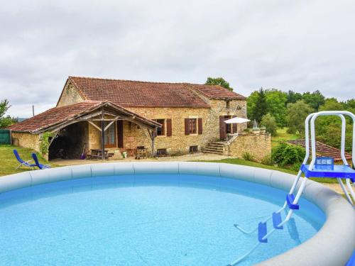 a large swimming pool in front of a stone house at Heavenly holiday home with pool in Villefranche-du-Périgord