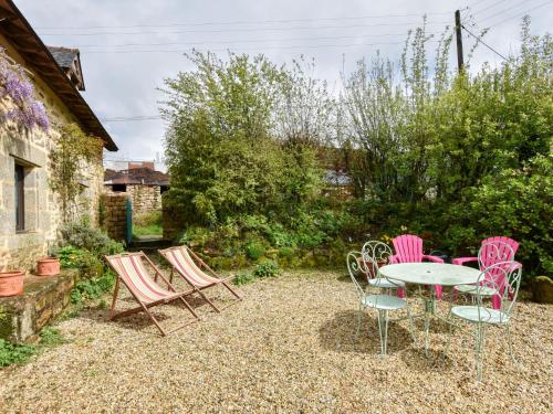 a patio with a table and chairs in a yard at Cosy holiday home with terrace near Quimperl in Coatviller