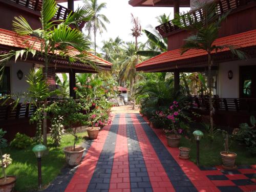 a walkway in front of a house with plants at Samsara Harmony Beach Resort in Varkala