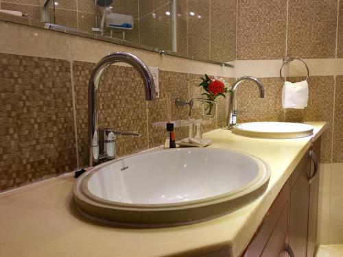 a bathroom with two sinks and two faucets at Curacao Suites Hotel in Willemstad