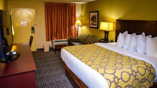 a hotel room with a large bed and a television at Baymont by Wyndham Columbus GA in Columbus