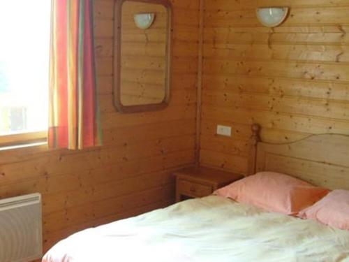una camera con un letto in una baita di tronchi di Cozy chalet with a dishwasher, in the High Vosges a Le Ménil