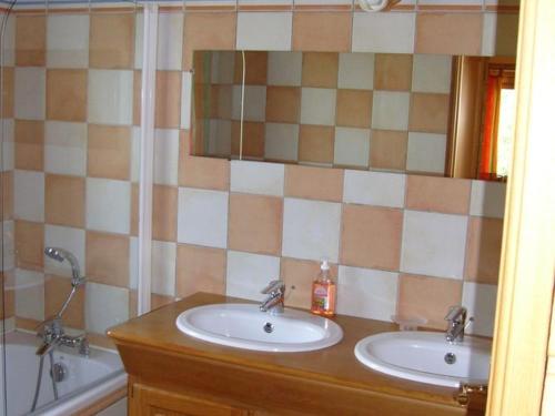 La salle de bains est pourvue de 2 lavabos et d'un miroir. dans l'établissement Cozy chalet with a dishwasher, in the High Vosges, à Le Ménil