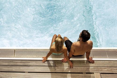 a man and woman sitting on a bench next to a swimming pool at ...mein Graml in Bad Füssing