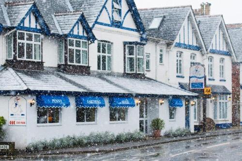 a building on a street with snow on it at Penny Farthing Hotel & Cottages in Lyndhurst