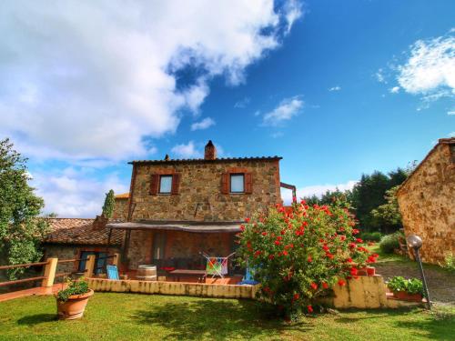 an old stone house with flowers in the yard at Belvilla by OYO Casa Tiglio in San Quirico dʼOrcia