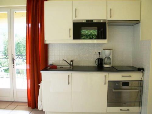 une cuisine avec des armoires blanches et un comptoir dans l'établissement Apartment in Montbrun near Mont Ventoux, à Montbrun-les-Bains