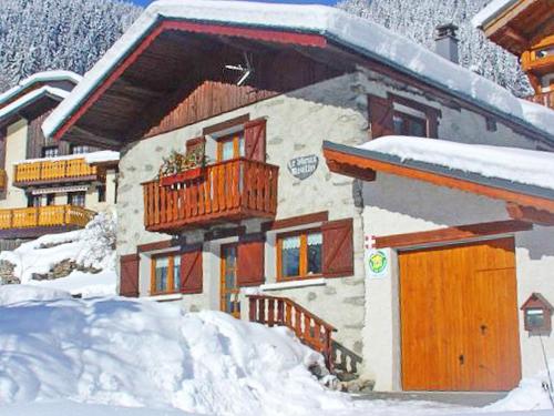 a building with a balcony in the snow at Charming Chalet in Champagny en Vanoise near Ski Area in Le Villard
