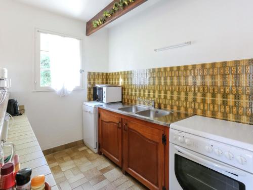une cuisine avec un évier et un micro-ondes dans l'établissement Holiday Home in Bormes near Beaches & Pool, à Bormes-les-Mimosas