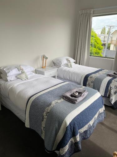 a bedroom with two beds and a window at Home By Hagley Park in Christchurch