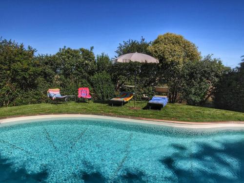 een zwembad met 2 stoelen en een parasol bij Belvilla by OYO Camillo Tosco in Valiano