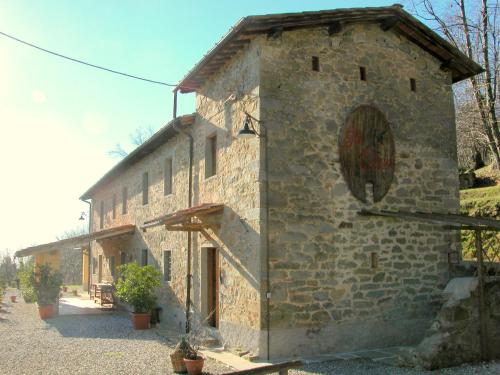 a stone building with a clock on the side of it at Belvilla by OYO Olivi Verde in San Quirico