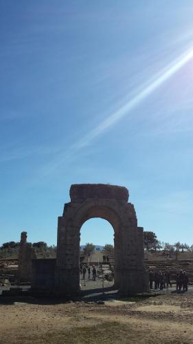 a stone archway with a group of people walking around at Casa Rural con encanto "Los Postigos" in Baños de Montemayor