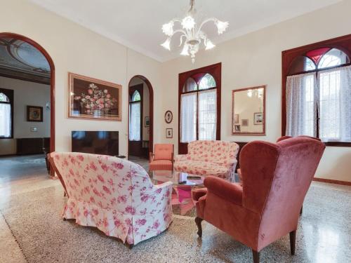 a living room with chairs and a table and a chandelier at Belvilla by OYO Villa Fiorita Due in Romano D'Ezzelino