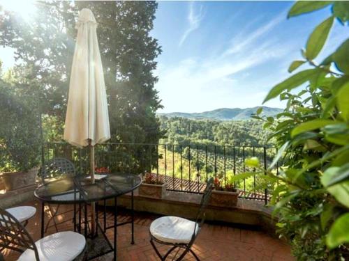 a patio with a table and chairs and an umbrella at Stunning Holiday Home in Figline Valdarno with Barbecue in Figline Valdarno