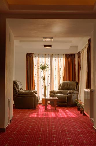 a living room with two couches and a table at Cabana Bistrita in Durau