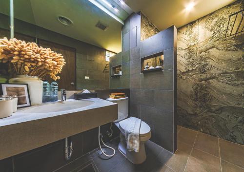 a bathroom with a sink and a toilet at Bhava Residence in Hat Yai