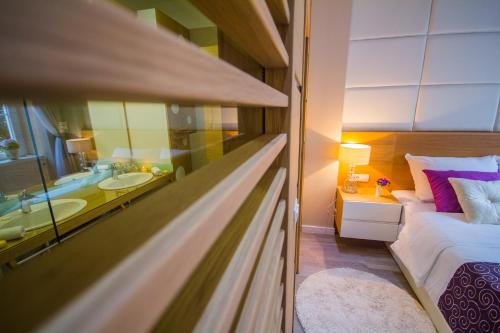 a bedroom with a bed and a bathroom with a tub at Peninsula Luxury Rooms in Zadar