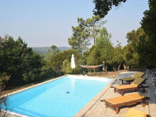 - une piscine avec des chaises et un hamac à côté dans l'établissement A Perfect villa with pool terrace and garden, à Alcobaça