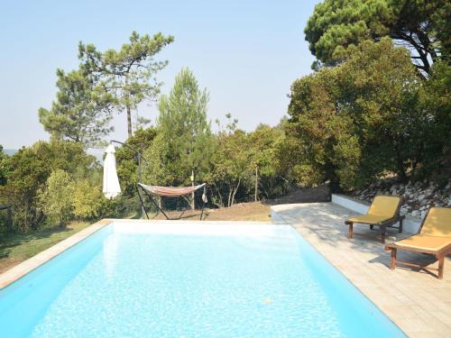 una piscina con 2 sillas y una mesa en A Perfect villa with pool terrace and garden en Alcobaça