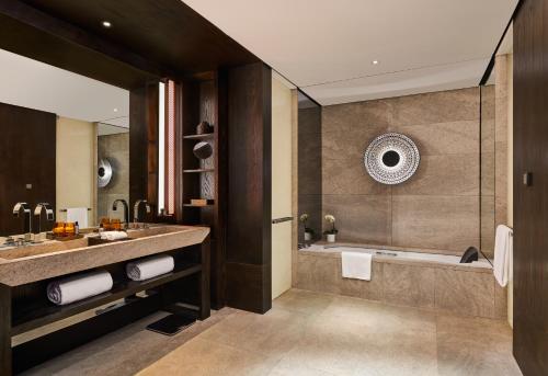 a bathroom with a large tub and a sink at Hyatt Regency Wuhan Optics Valley in Wuhan