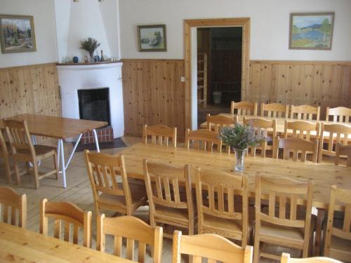 SysslebäckにあるBeautiful Holiday Home in Syssleb ck with Saunaの木製のテーブルと椅子、暖炉が備わる客室です。