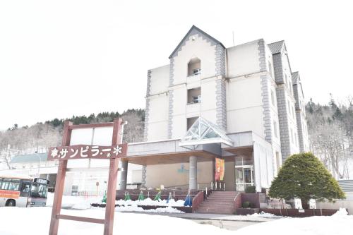 a building with a street sign in front of it at Nayoro Onsen Sunpillar in Nayoro