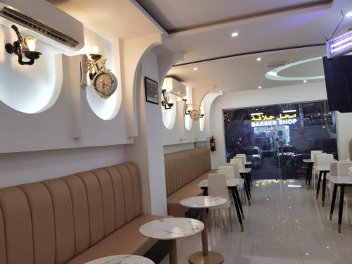 un restaurante con mesas y sillas y un reloj en la pared en Al Rayyan Hotel Apartments Muscat, en Seeb