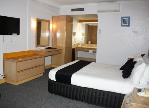 a hotel room with two beds and a television at Capital Airport Motel in Queanbeyan
