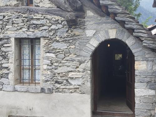 a stone building with a door and a window at Tepilanti in Cerentino