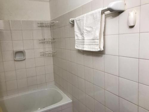 a bathroom with a tub and a toilet and towels at DEPARTAMENTO TORRE IV in Comodoro Rivadavia