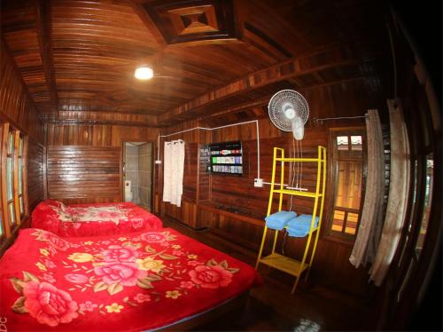 a bedroom with a red bed and a yellow ladder at ไร่กะหล่ำหวาน ภูทับเบิก in Ban Phu Pun