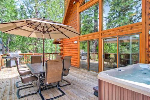 a wooden deck with a table and a hot tub at Yosemite's Scenic Wonders - 6BR/4BA Tri-Level Home in Yosemite West