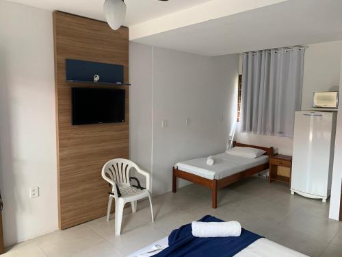 a hotel room with a bed and a chair at Beach House Floripa - Sunset in Florianópolis