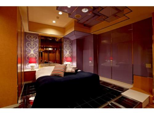 a bedroom with a large bed with two lamps on it at Hotel Savoy - Adult Only in Tokyo